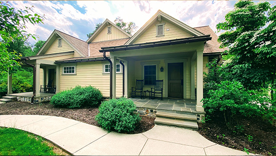 Cottage With Private Outdoor Entrances with two rocking chairs outside of the cottage entrance.