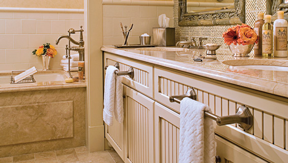 Bathroom inside of woodside cottage, with his and her sinks, The Spa handsoap and hair products, fresh flowers, and large bathtub/