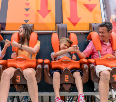 family of four fist bumping each other after they get strapped into their seats on the Triple Tower.