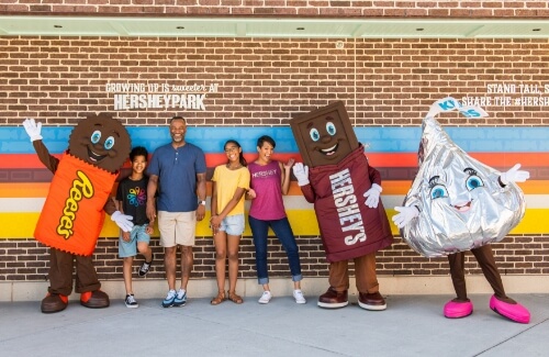 A family posing with Hershey Characters