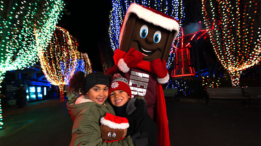 Kids posing with Hershey character dressed for Christmas.
