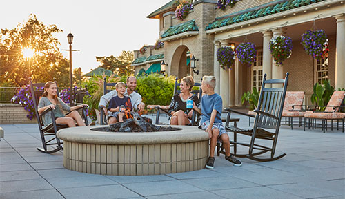 Family gathered at firepit at The Hotel Hershey
